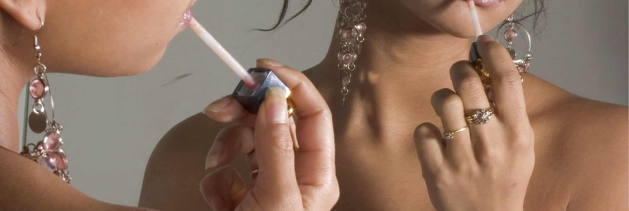 Close-up of a hand lighting a cigarette near a woman's face with an earring.